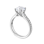 The simplicity of this single row channel set diamond shank engagement ring with four prong solitaire is simply gorgeous.